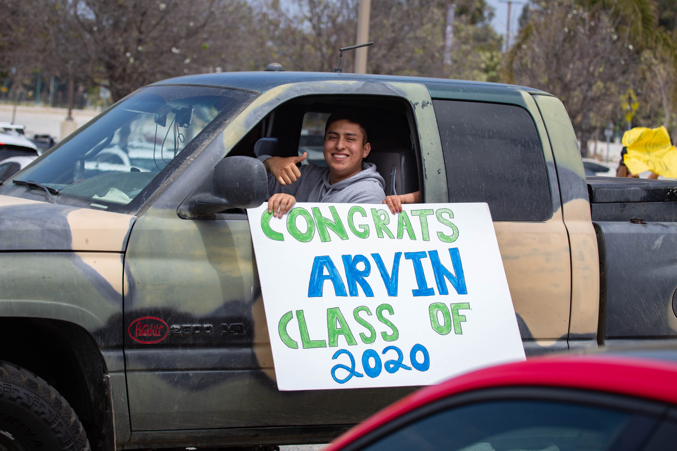 graduate in a truck with a congrats arvin class of 2020 sign